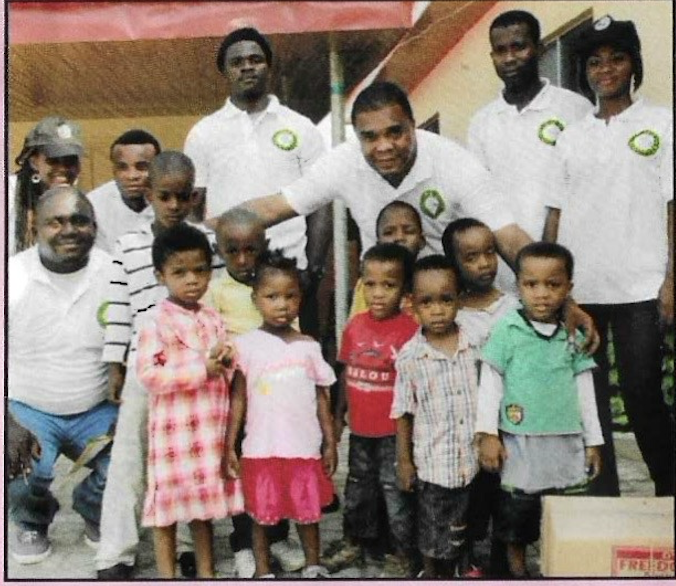 KUTH volunteers in their branded polos gathered for a group photo with the children of the home