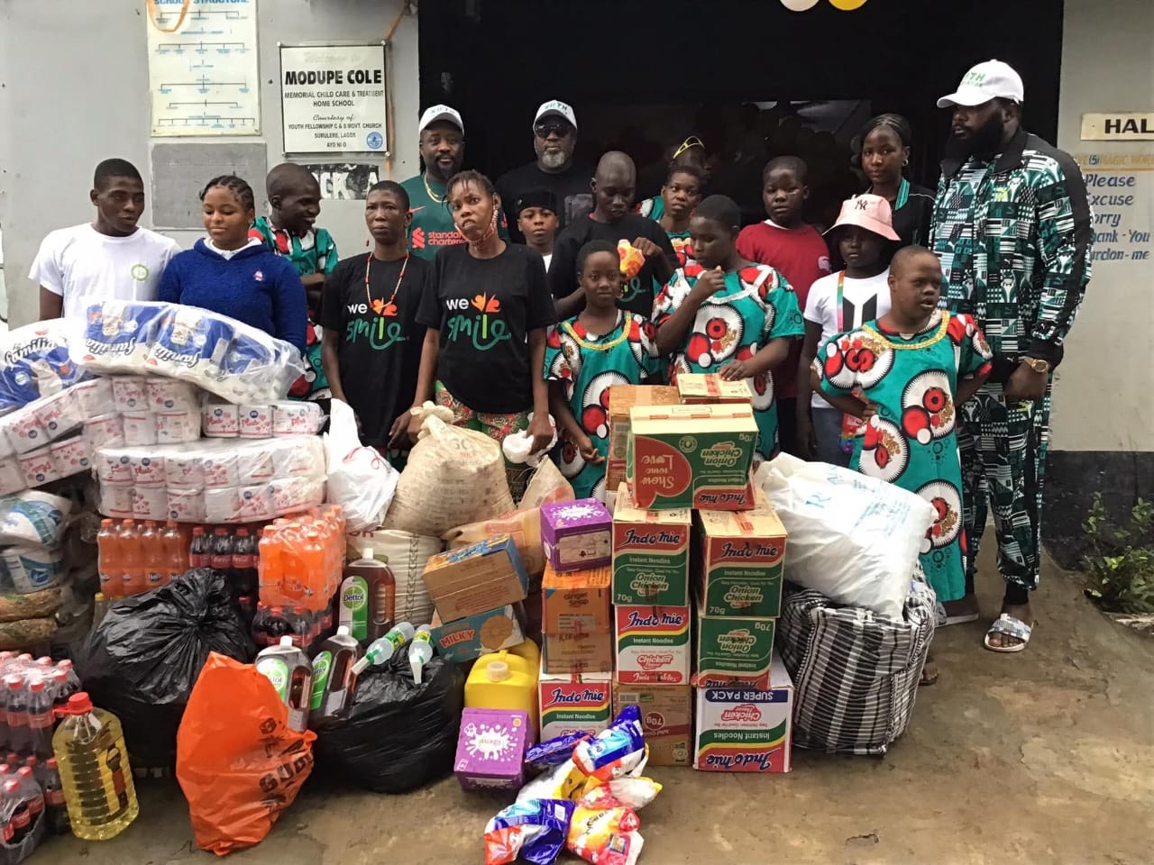Group photo with children at Modupe Cole Home surrounded by donated supplies