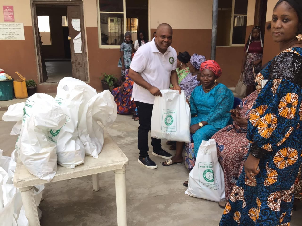 Prince Francis Chilaka presenting a donation bag to a widow